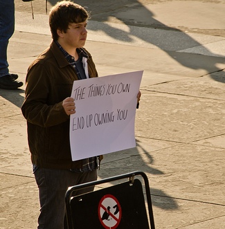 Man holding hand-written sign. Photo used under Creative Commons license courtesy of garryknight of Flickr