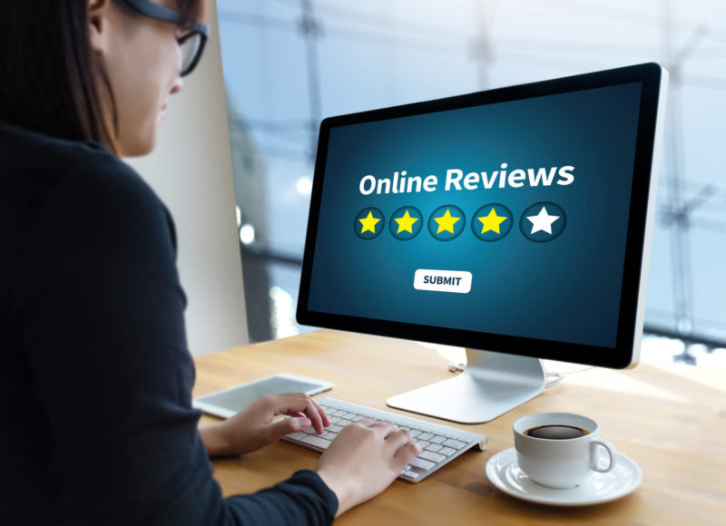 Woman at computer screen showing image of online reviews