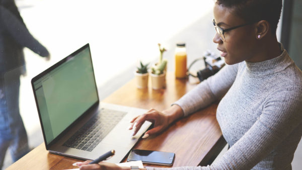 woman-searching-computer-making-notes-stock